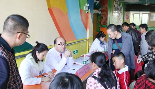 医务人员为孩子们进行公益体检及家长咨询